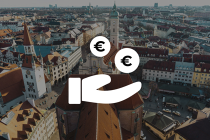 Symbolgrafik einer Hand mit zwei Euro-Zeichen vor einer Luftaufnahme einer bayerischen Stadt – Symbol für Wirtschaft und Investitionen in Bayern und Hessen.