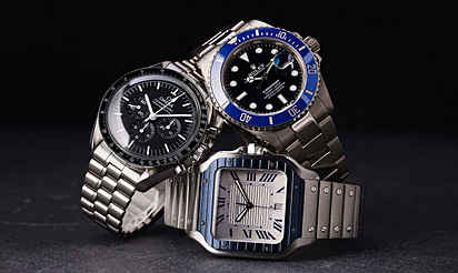 Drei Luxusuhren (Omega, Rolex, Cartier) als Symbol für Wertstabilität und Investition.