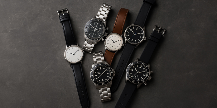 Uhrenkonvolut – verschiedene Armbanduhren ohne sichtbare Markenlogos auf dunklem Hintergrund